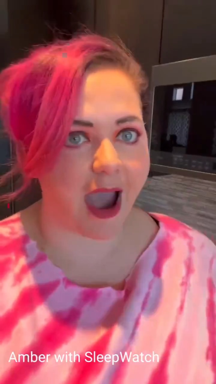 A pink-haired creator in a pink tie-dye top stares into the camera with a wide-eyed, open-mouthed shocked face, labeled “Amber with SleepWatch”